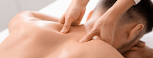 Man laying on massage bed having shoulders massaged