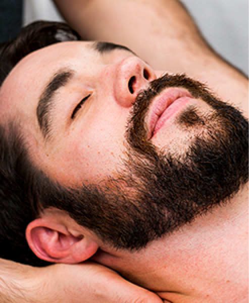 Man lying on massage table having shoulders massaged