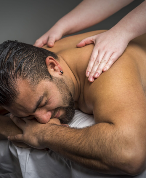 Man lying on massage table having shoulders massaged