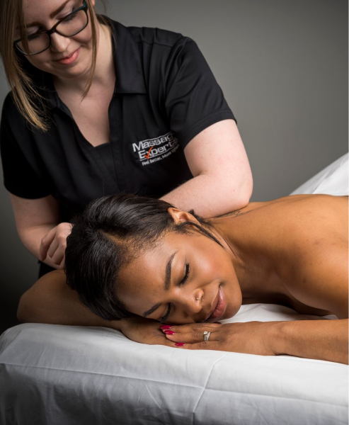 Woman lying on massage table with RMT massaging shoulder
