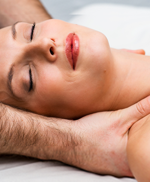 Woman lying on massage table having shoulders massaged