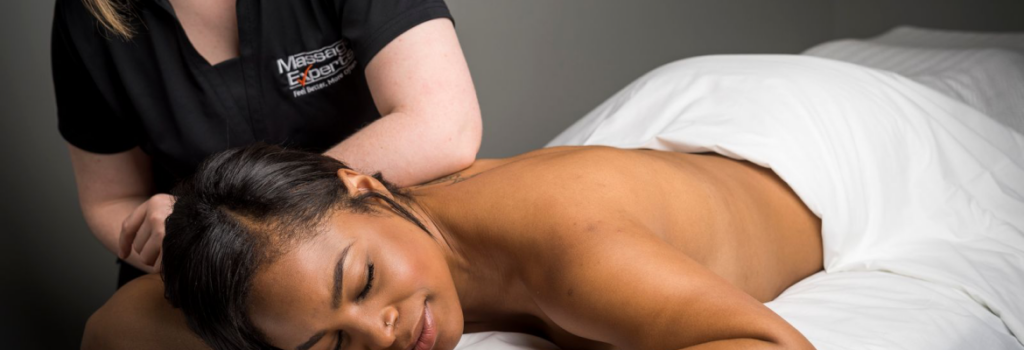 Woman lying on massage table with RMT massaging shoulder